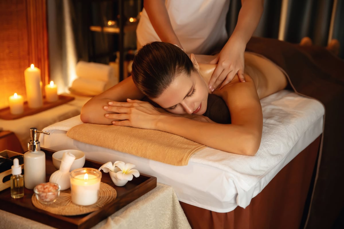 Mujer disfrutando de masaje relajante anti-estrés en spa con luz de velas